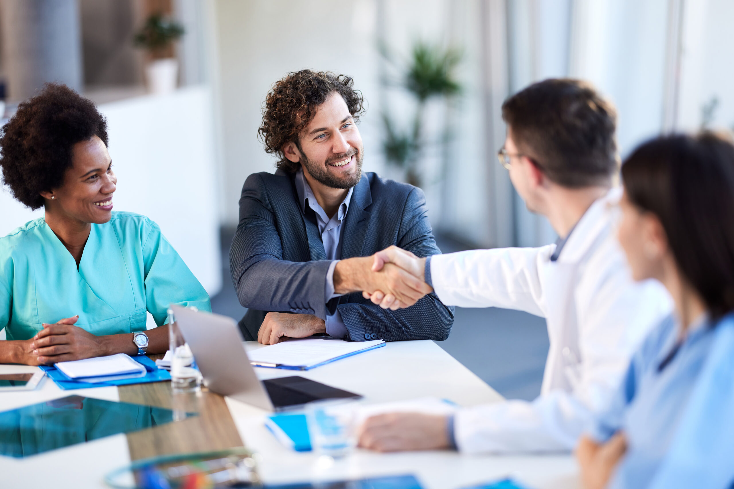 Happy male administrator came to a successful agreement with medical experts during a meeting in a hospital.